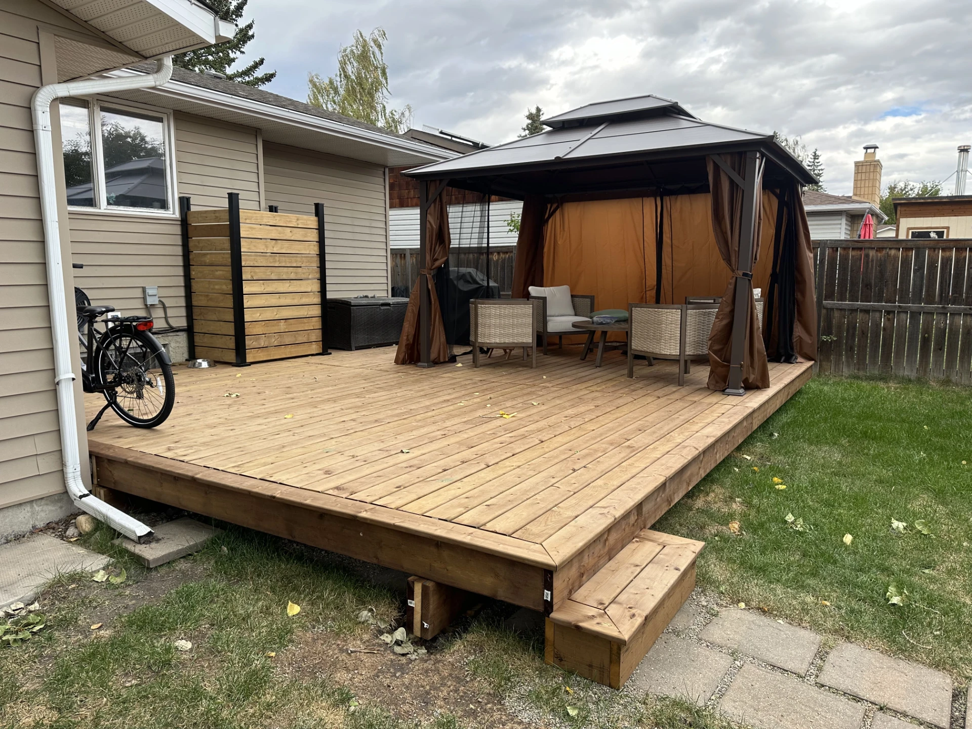 Angled view of deck, gazebo, and backyard lawn.