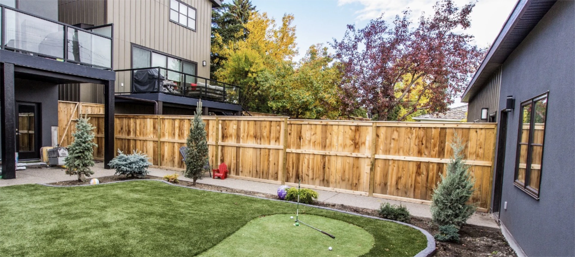 Backyard enclosed by a tall cedar privacy fence.