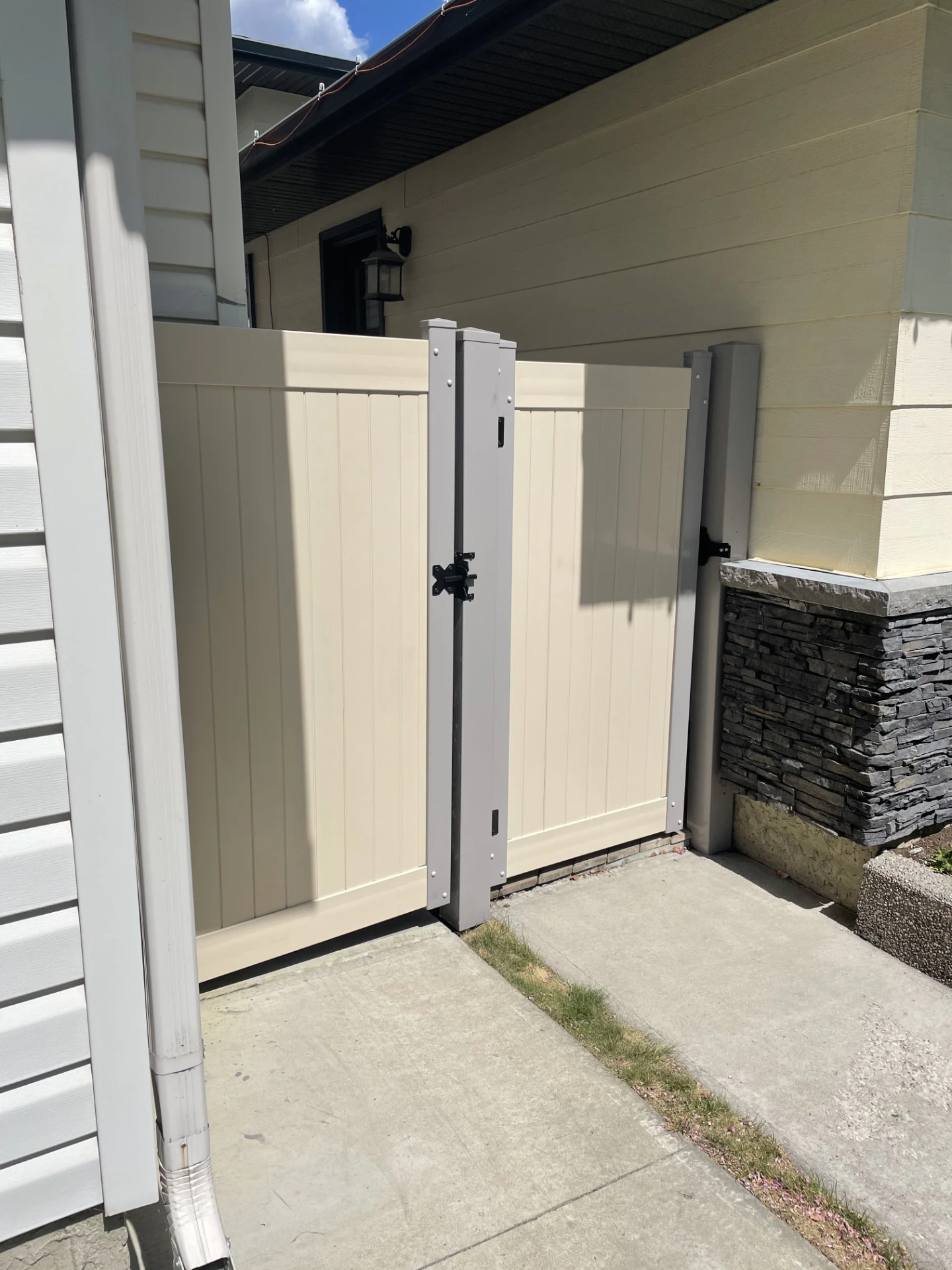 Beige vinyl side gate between house and walkway.