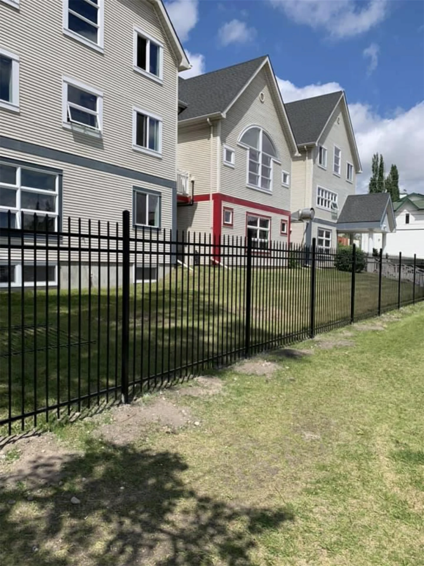 Black metal fence around apartment building.