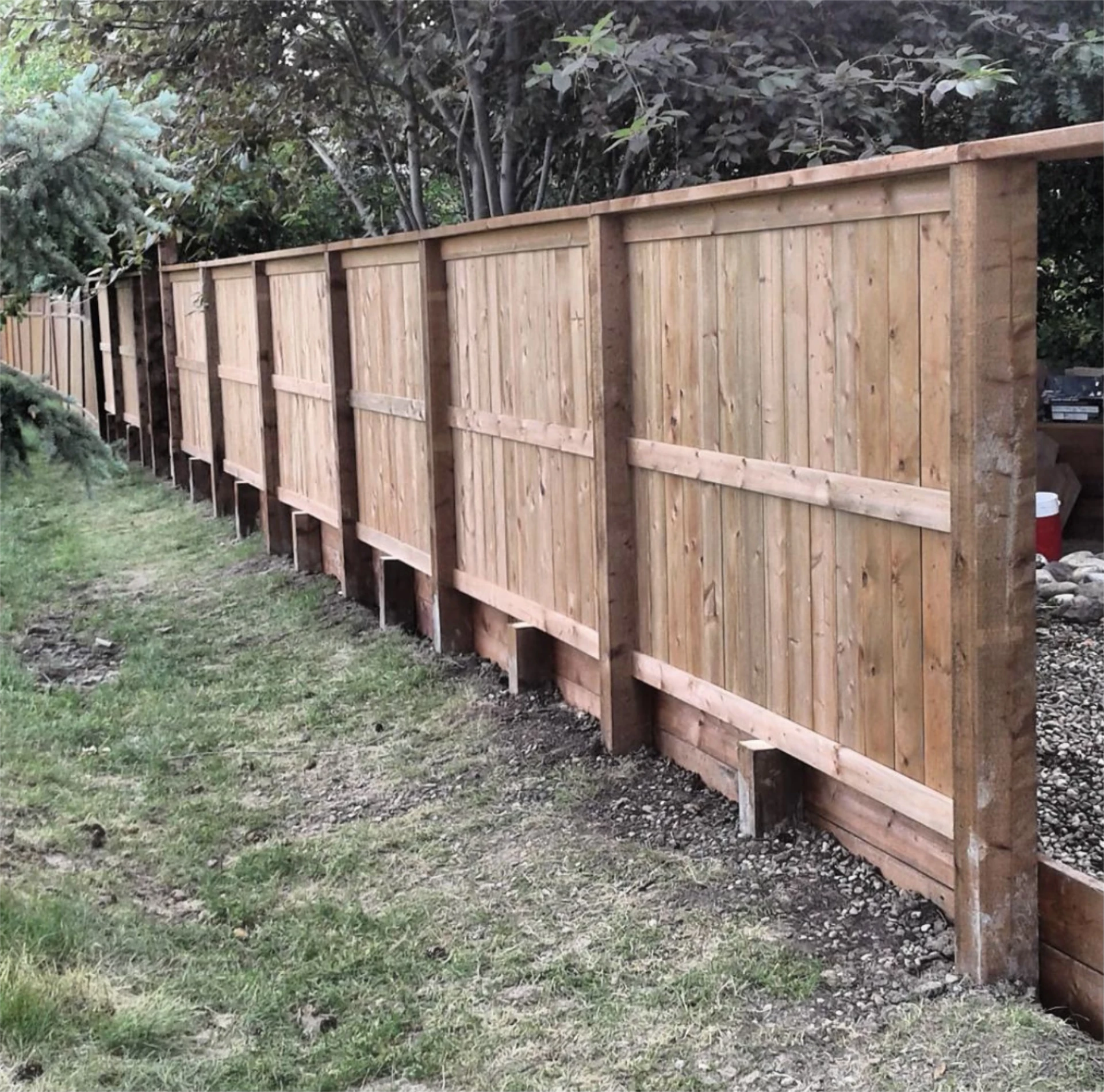 Board on board cedar fence with timber posts.