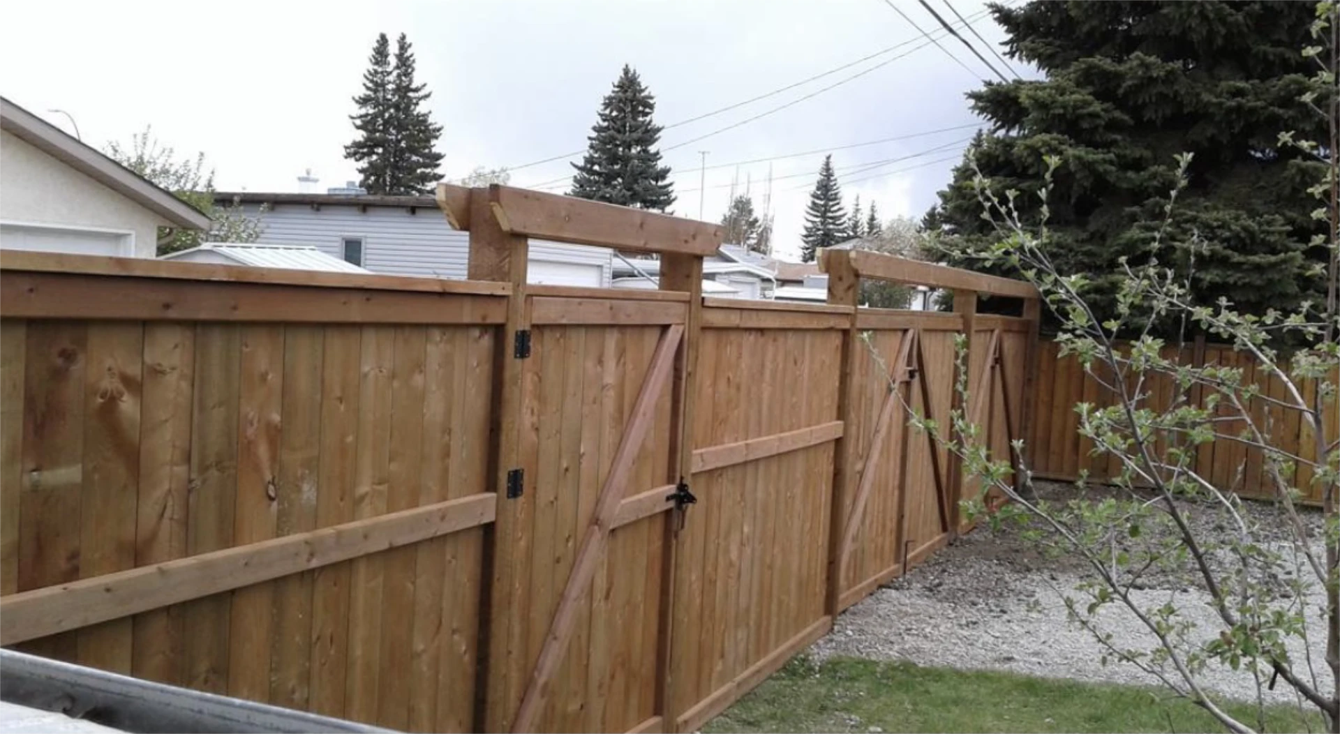 Cedar privacy fence with double gate and arbor tops.