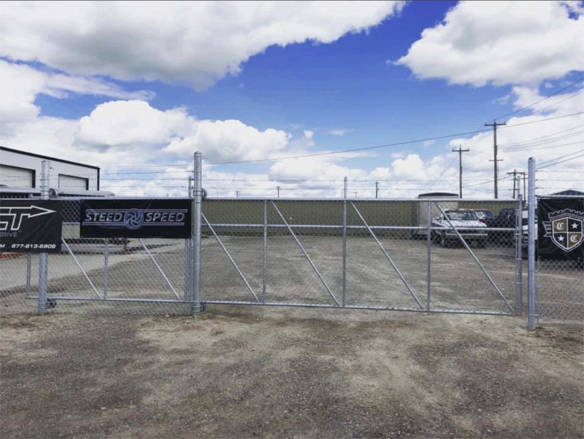 Chain link vehicle yard gate with barbed wire fencing