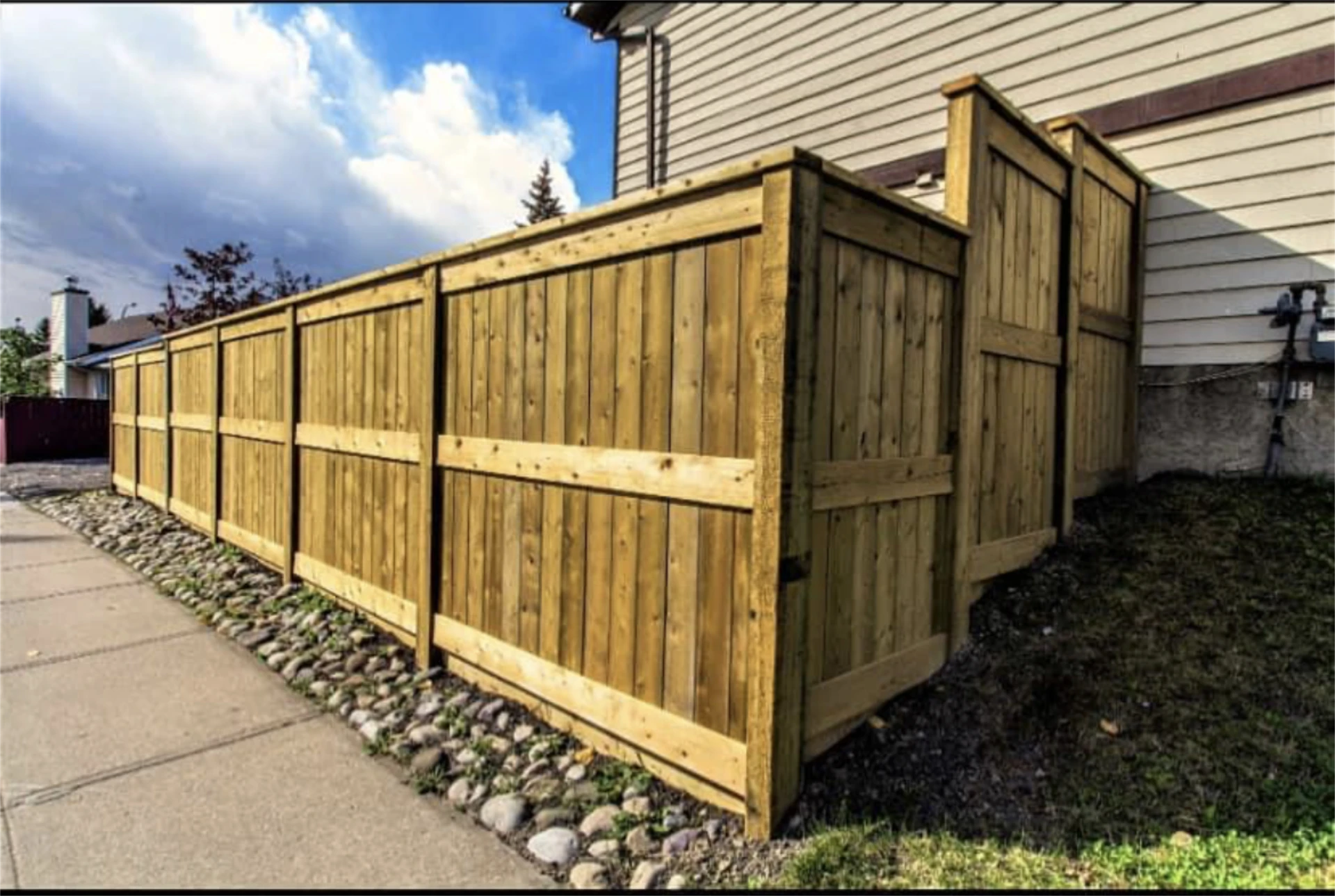 Corner section of pressure treated wood fence with gate