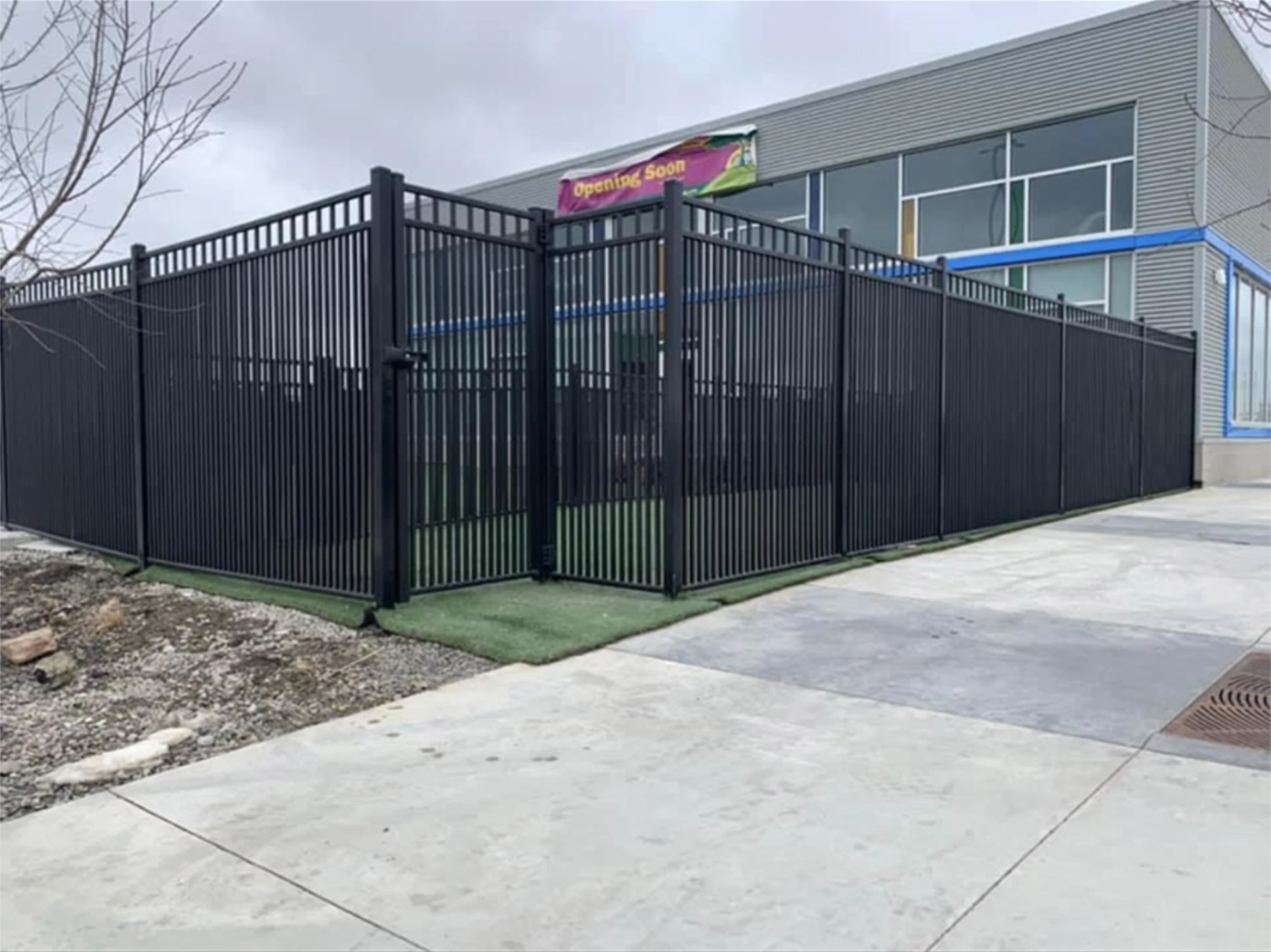 Exterior view of fenced playground beside a building.