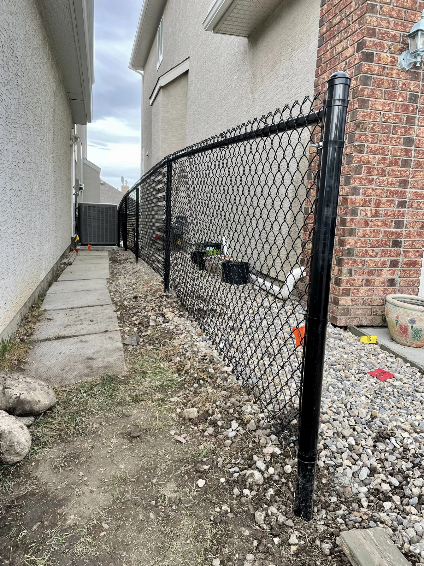 Finished black chain link fence along narrow side yard.