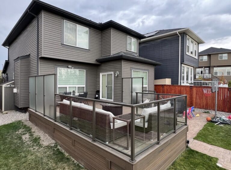 Side view of a residential deck with composite deck boards and glass and metal railing