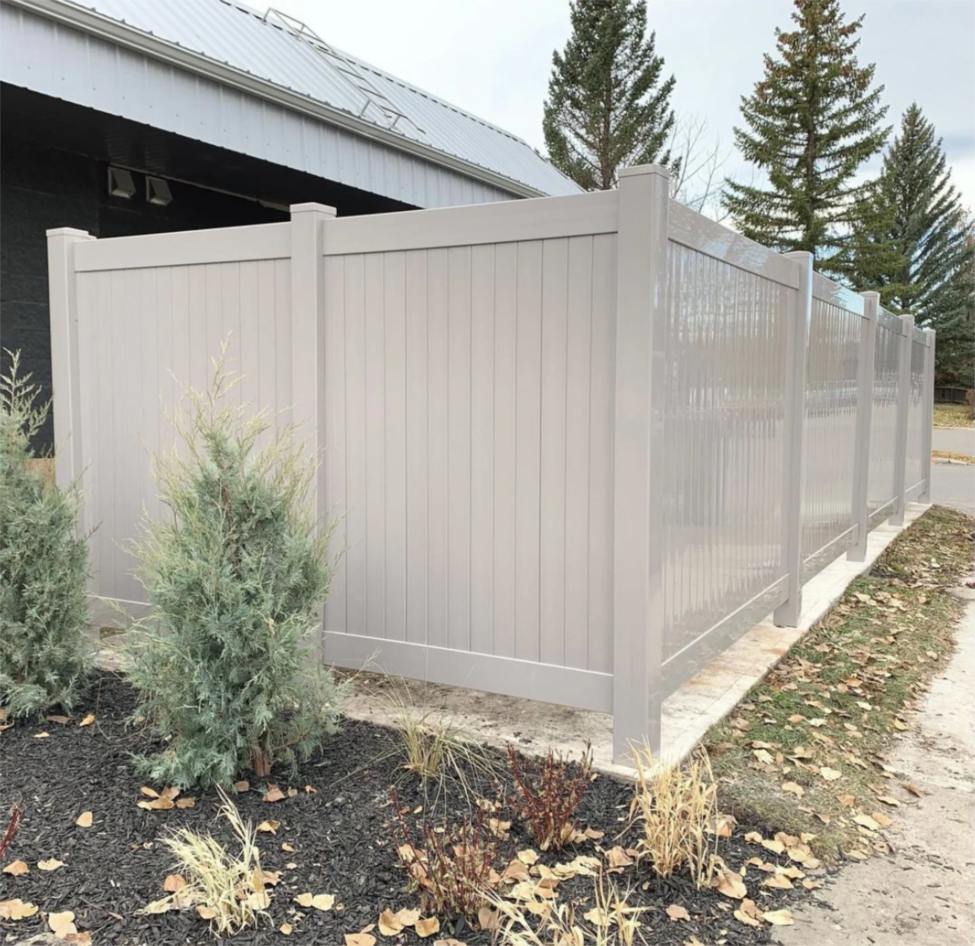 Light gray vinyl privacy fence around residential property.