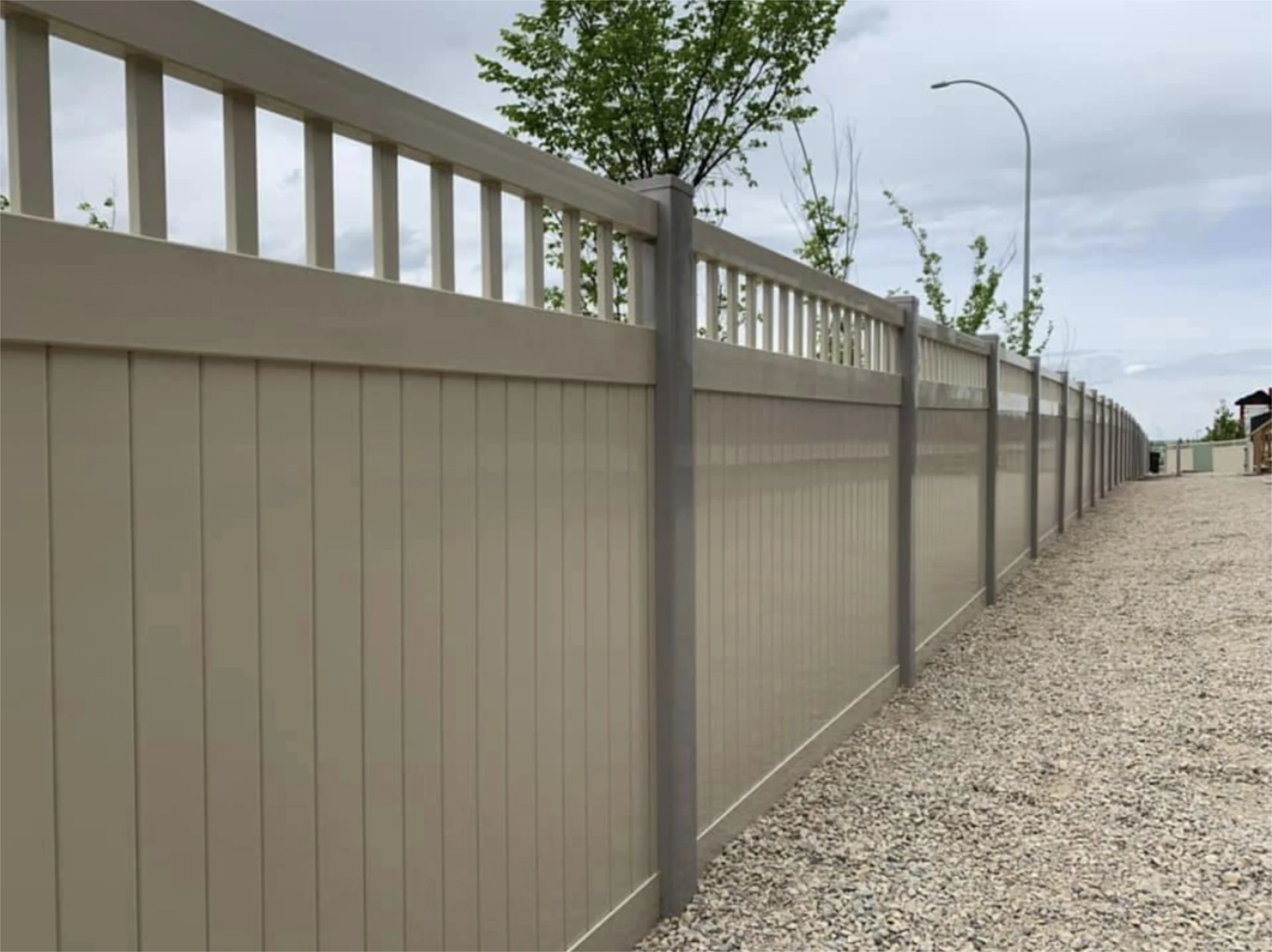 Light gray vinyl privacy fence with decorative top rail.