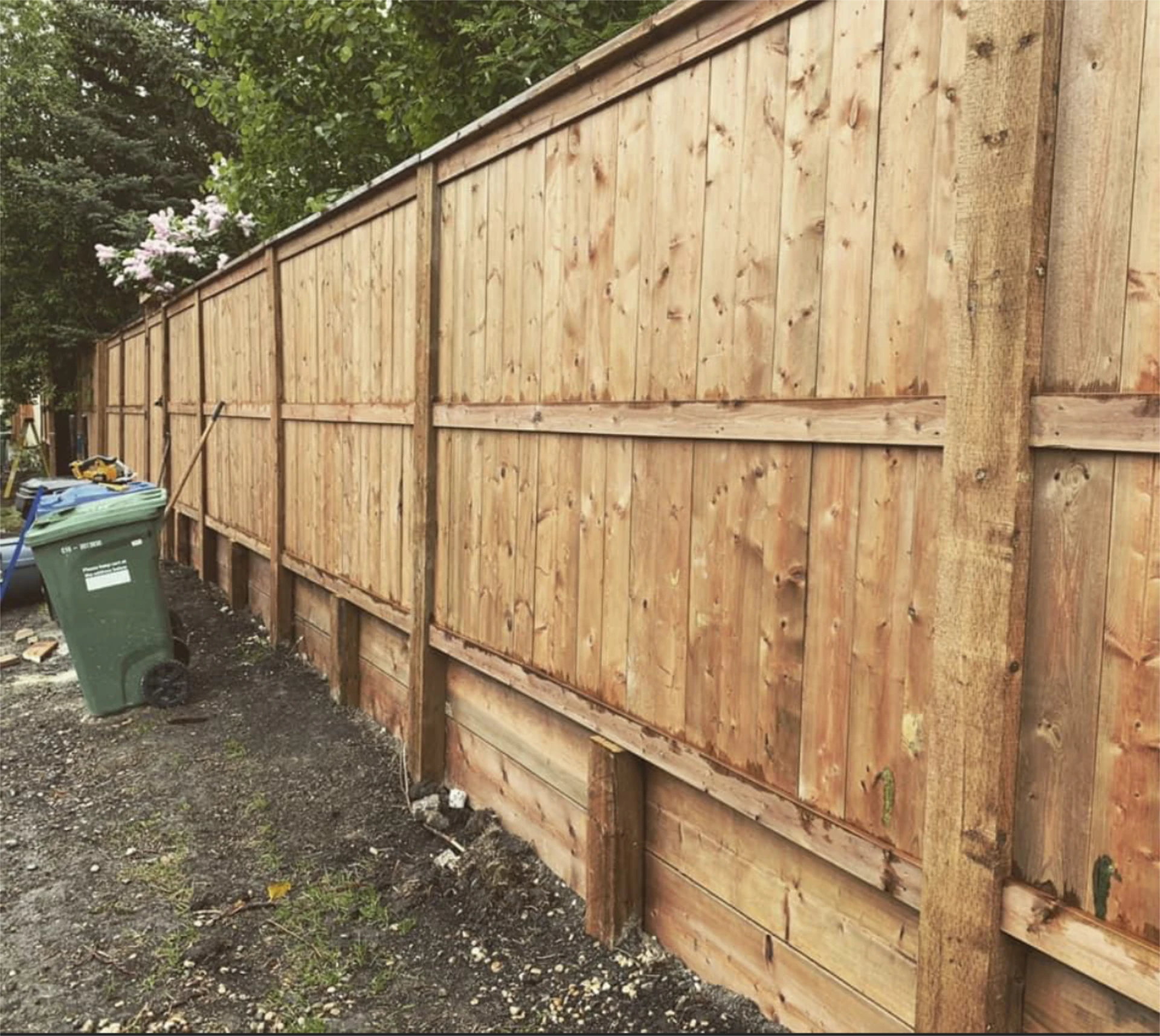 Long cedar fence with retaining boards.