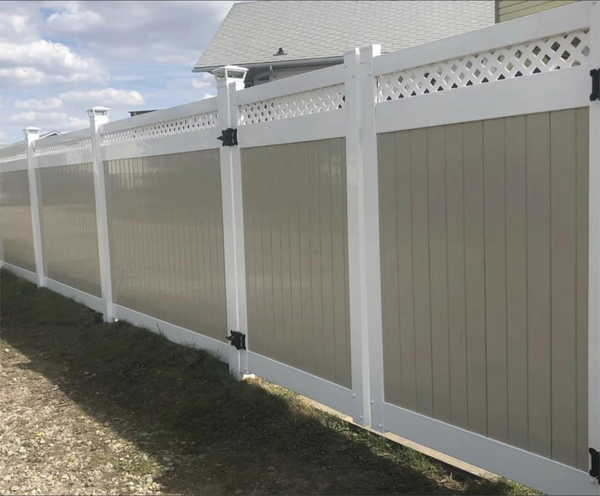 Long white and tan vinyl privacy fence with double gate.