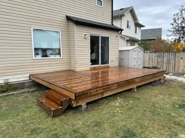 Low-level stained wood deck with steps built off a Calgary home
