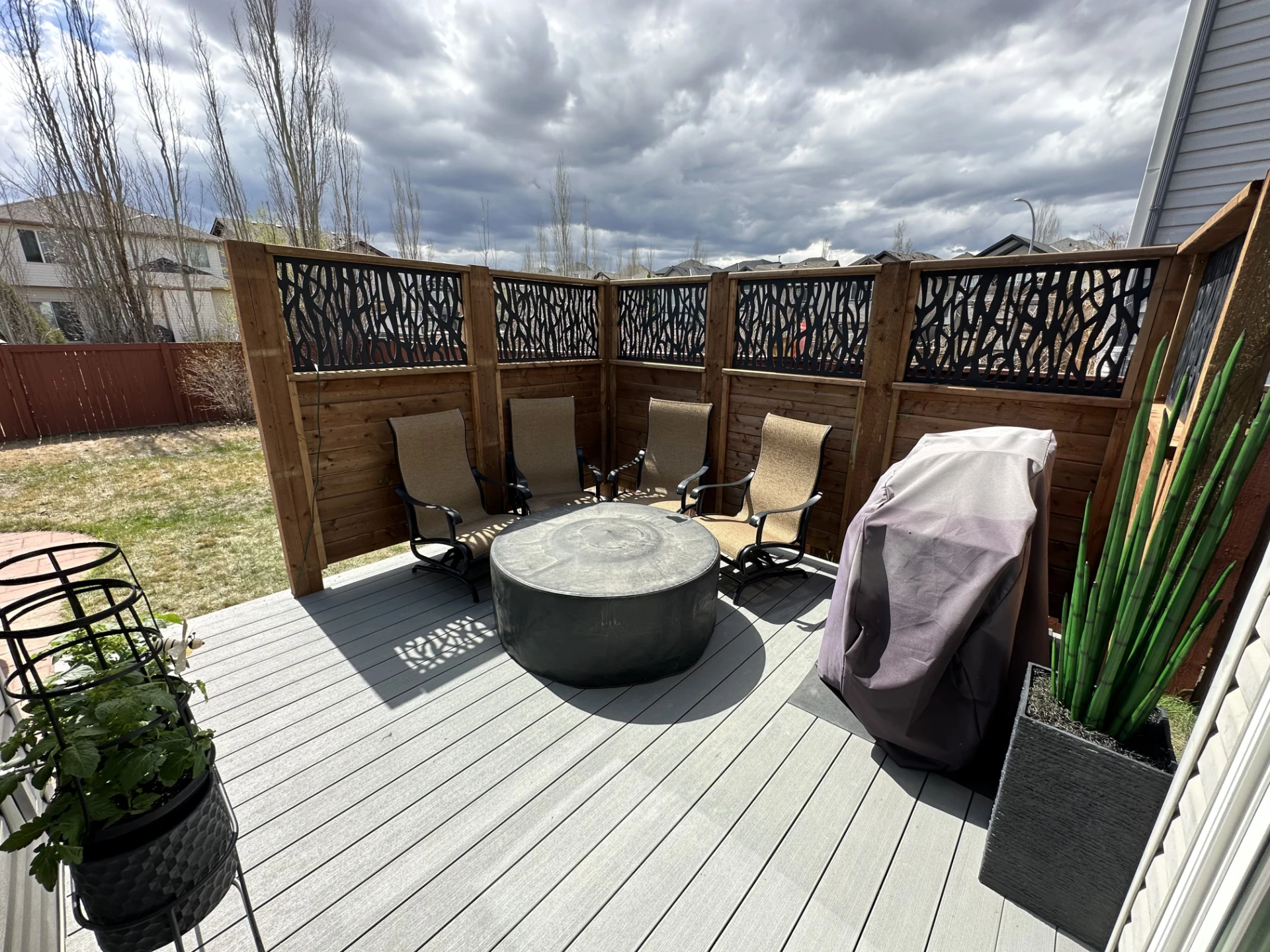 Modern deck lounge with covered grill and dramatic sky.
