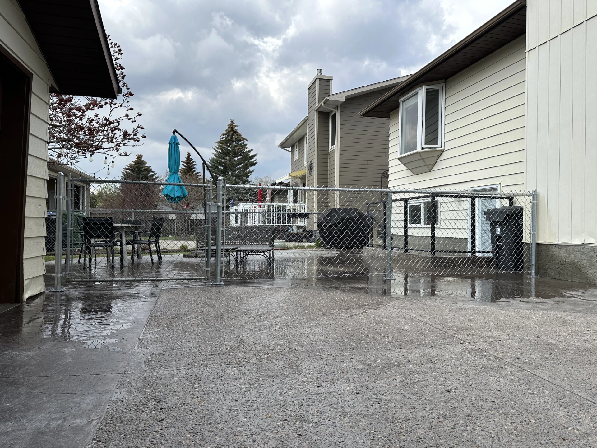 Wet backyard patio under dark storm clouds.