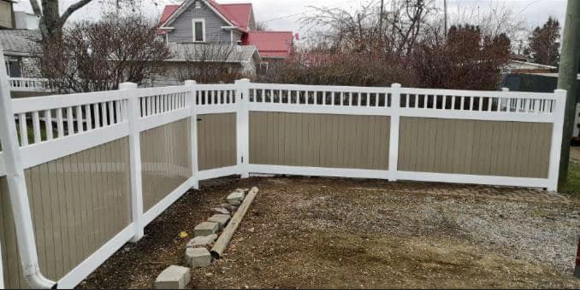 White and tan vinyl privacy fence with decorative top rail.