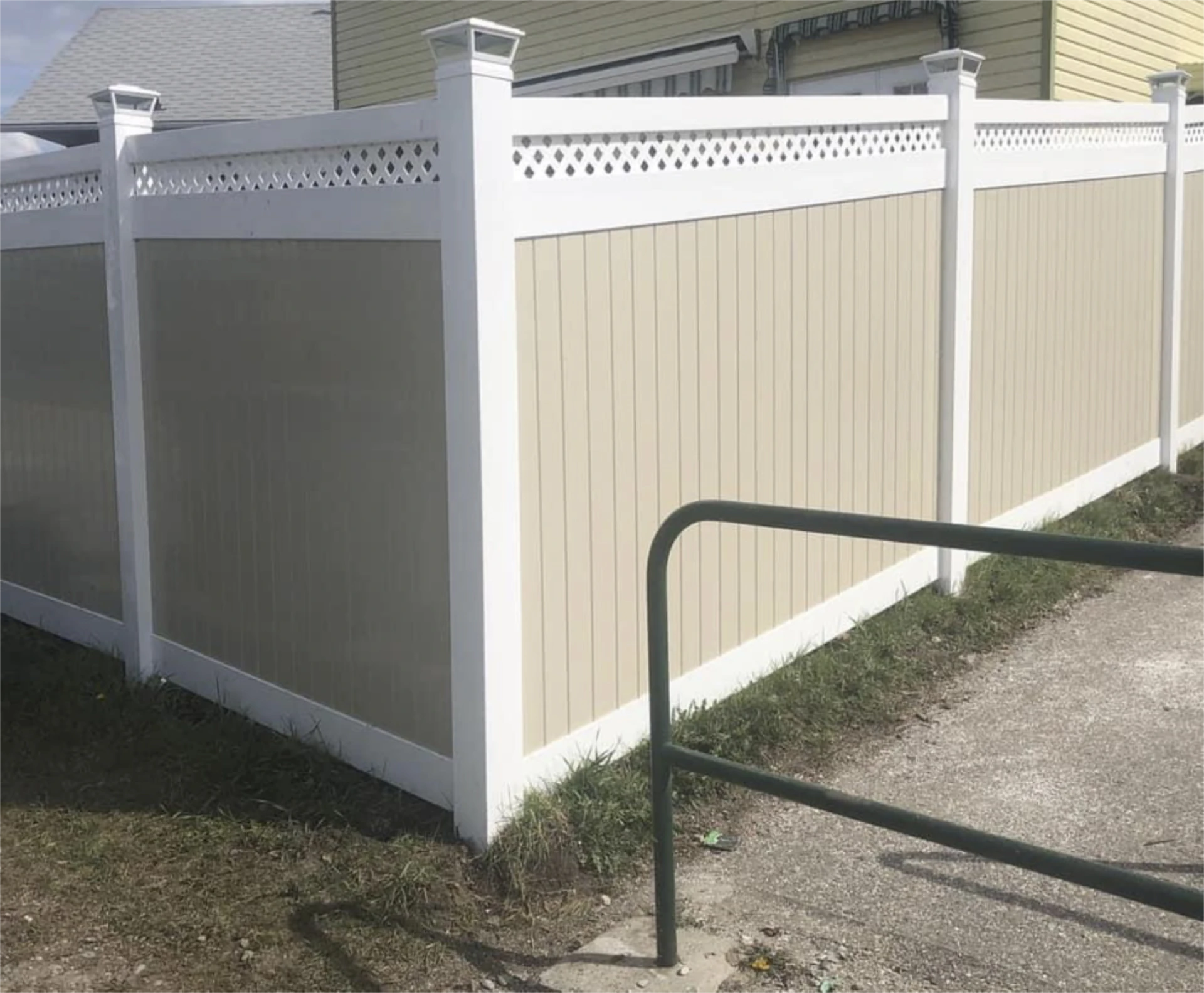 White vinyl fence with tan panels and lattice top.