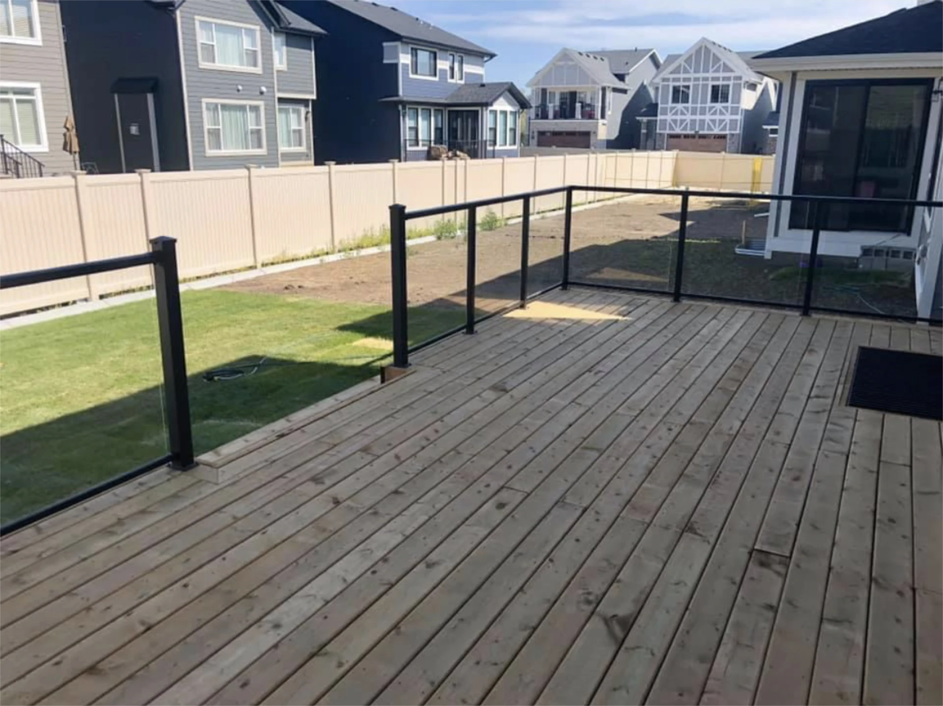 Wooden deck overlooking fenced backyard