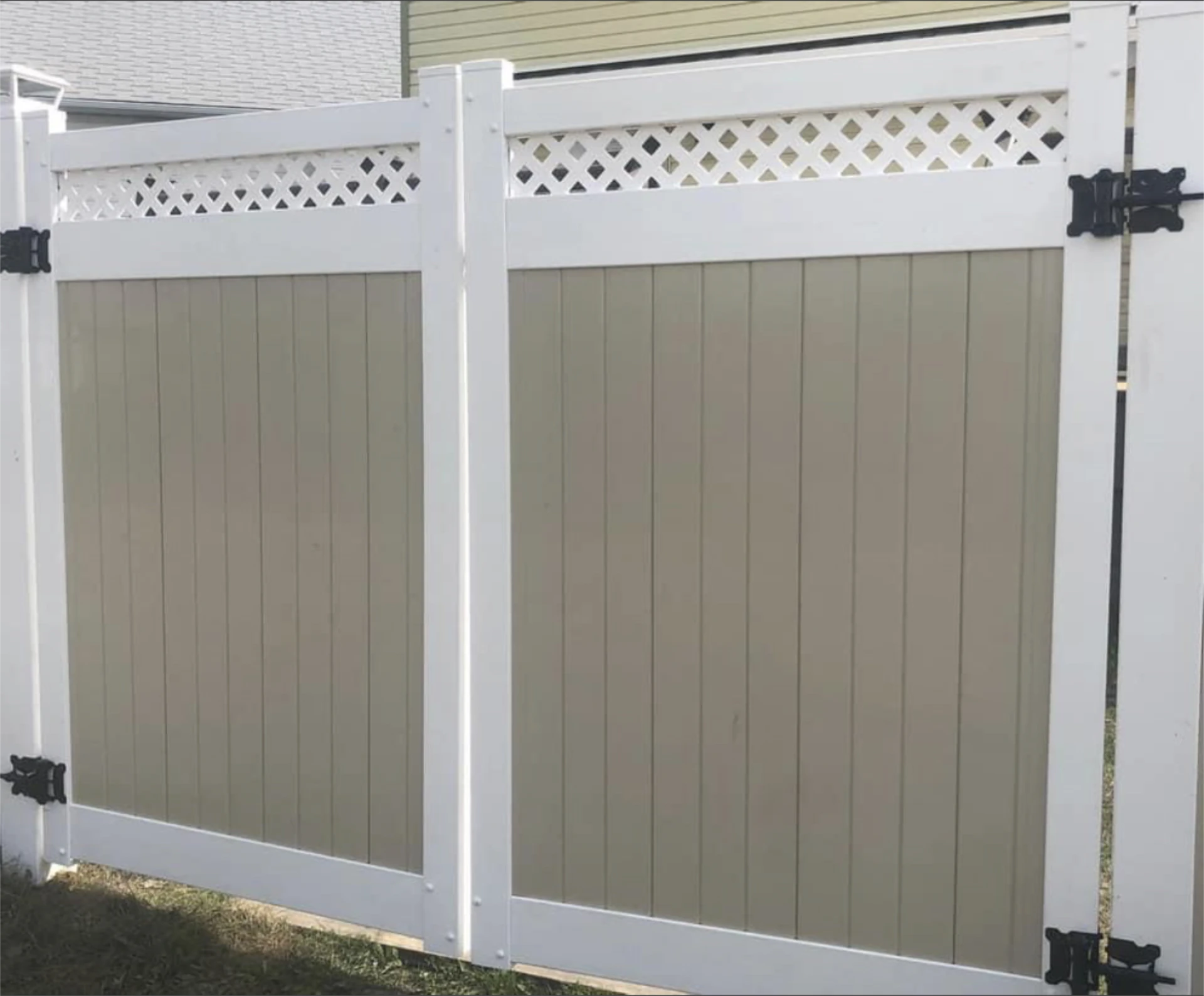 Close up of white and tan vinyl fence panels and gate hardware