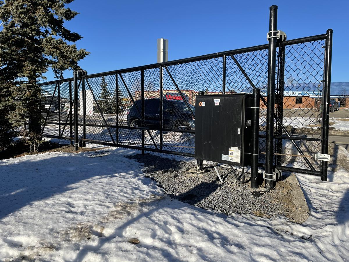 Commercial black chain link sliding gate with automatic operator in Calgary, AB