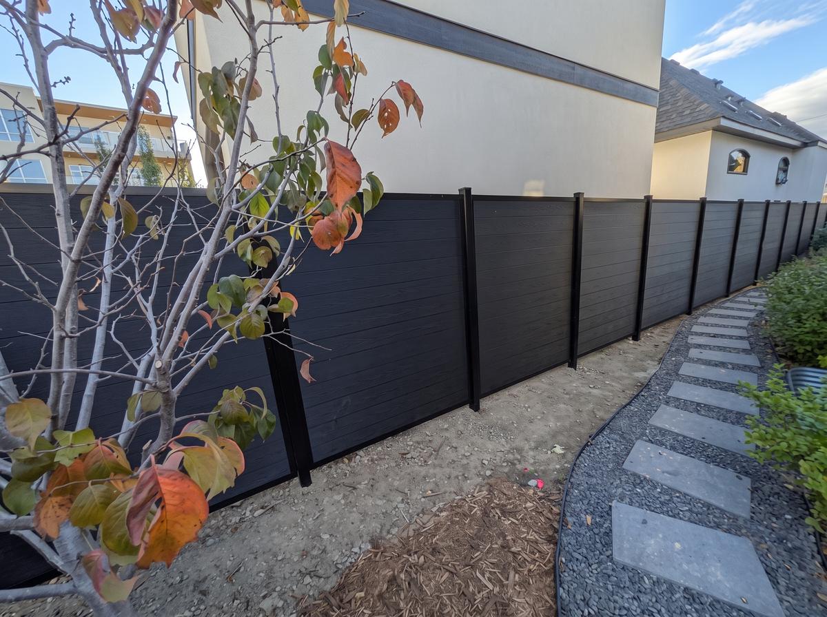 Black horizontal composite privacy fence along a side yard in Calgary, AB