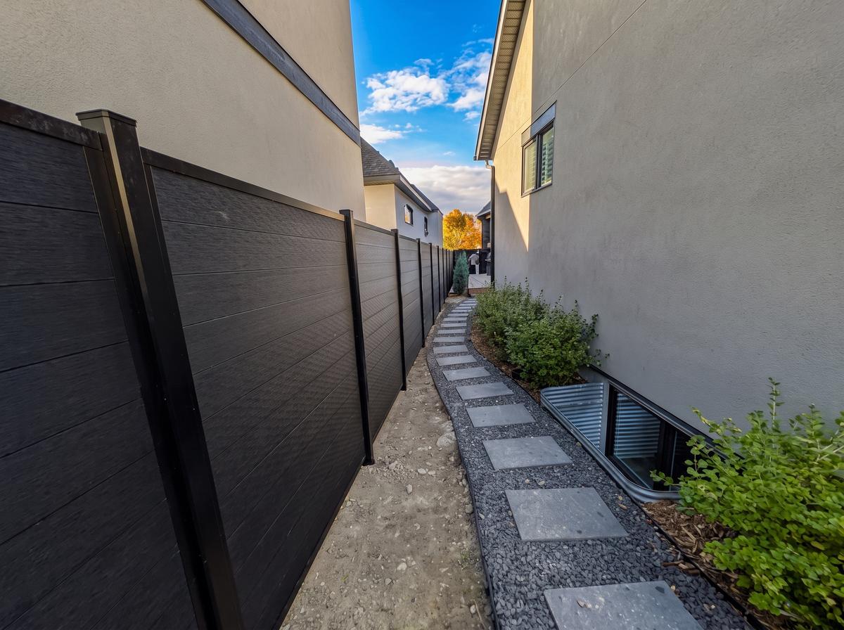 Black composite fence panels with aluminum posts along a narrow side yard in Calgary, AB
