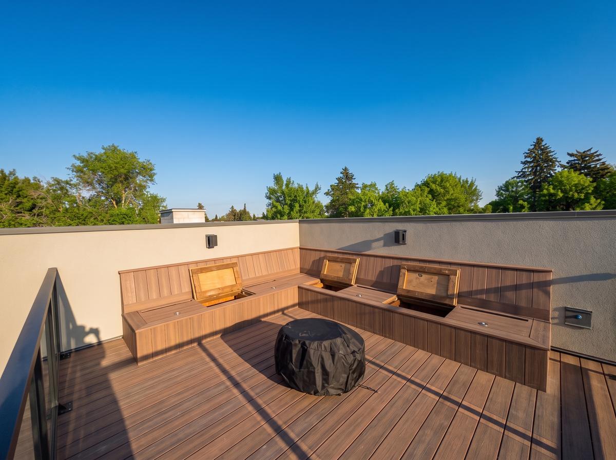 Composite rooftop deck with built-in bench seating and glass railing in Calgary, AB