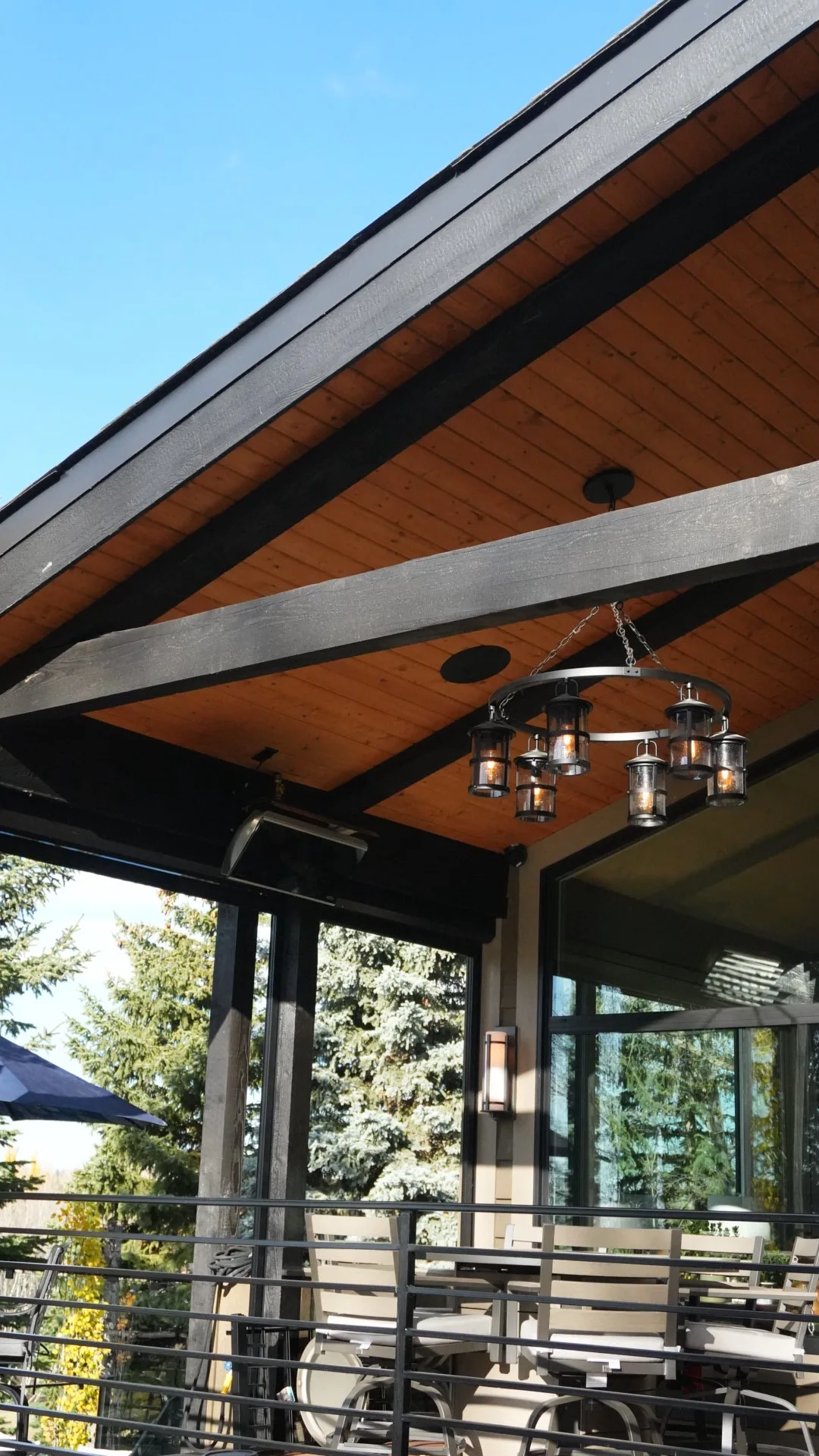 Gable end of a covered deck roof with cedar soffit and lantern chandelier in Calgary, AB
