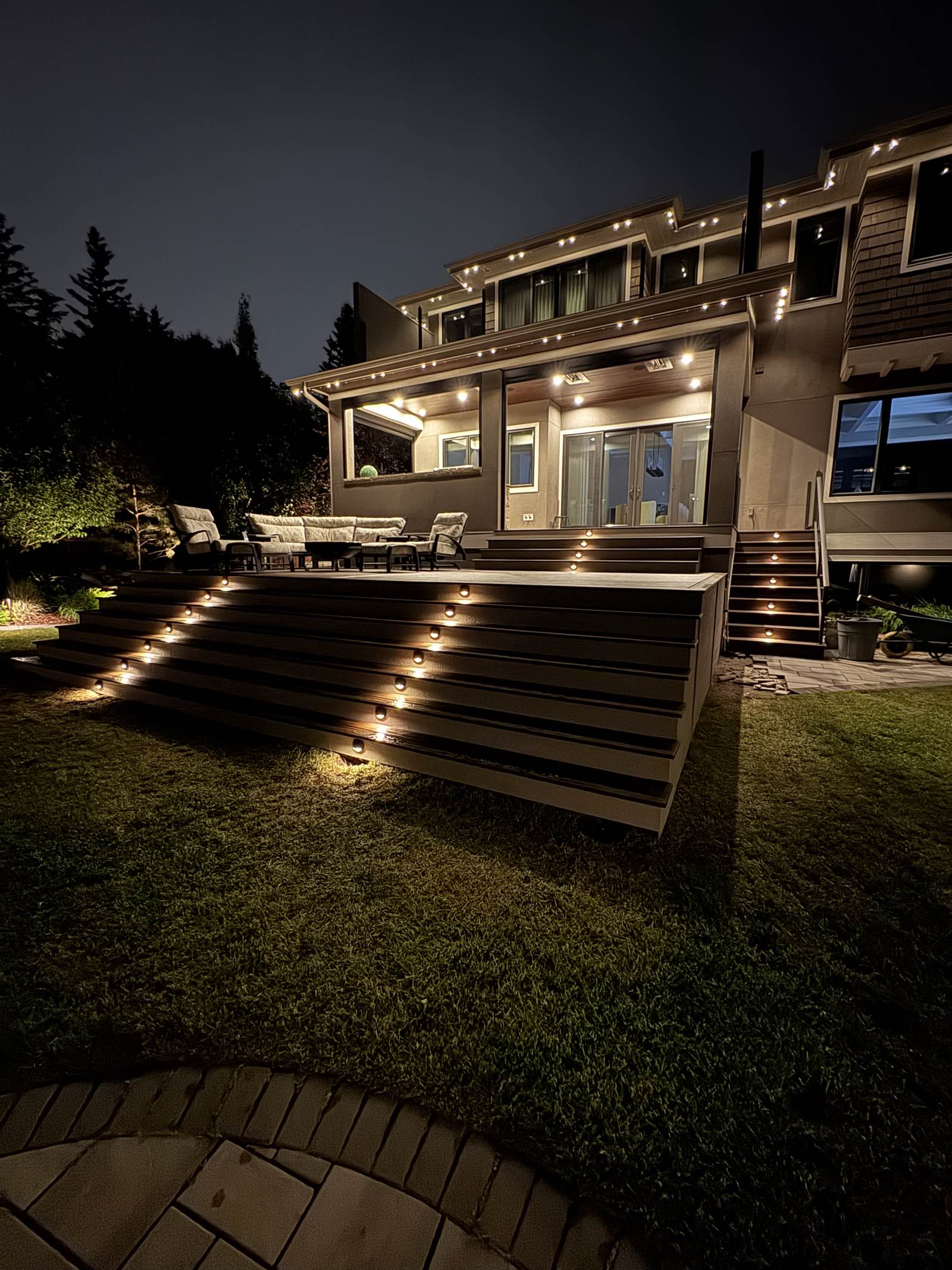 Covered porch and lit deck stairs at night, built in Calgary, AB