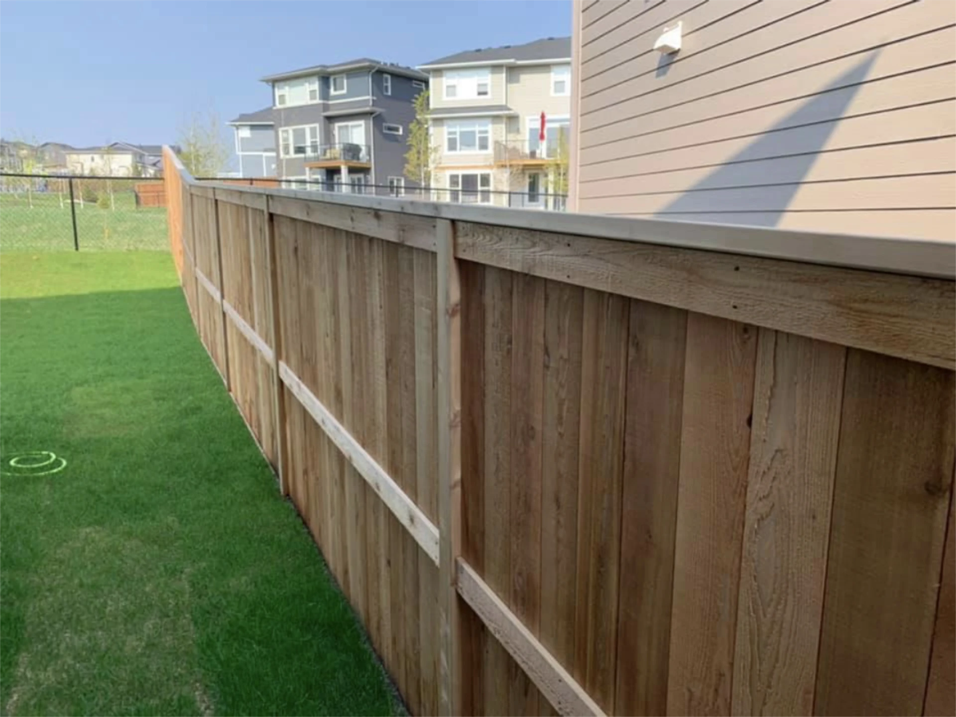 Long cedar privacy fence beside a grassy backyard