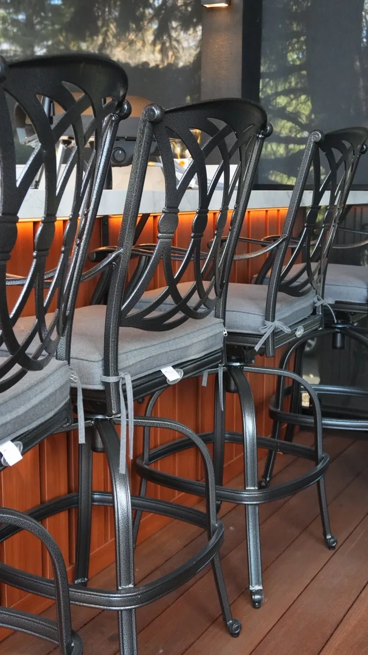 Bar stools at an outdoor kitchen counter with cedar skirting on a Calgary deck