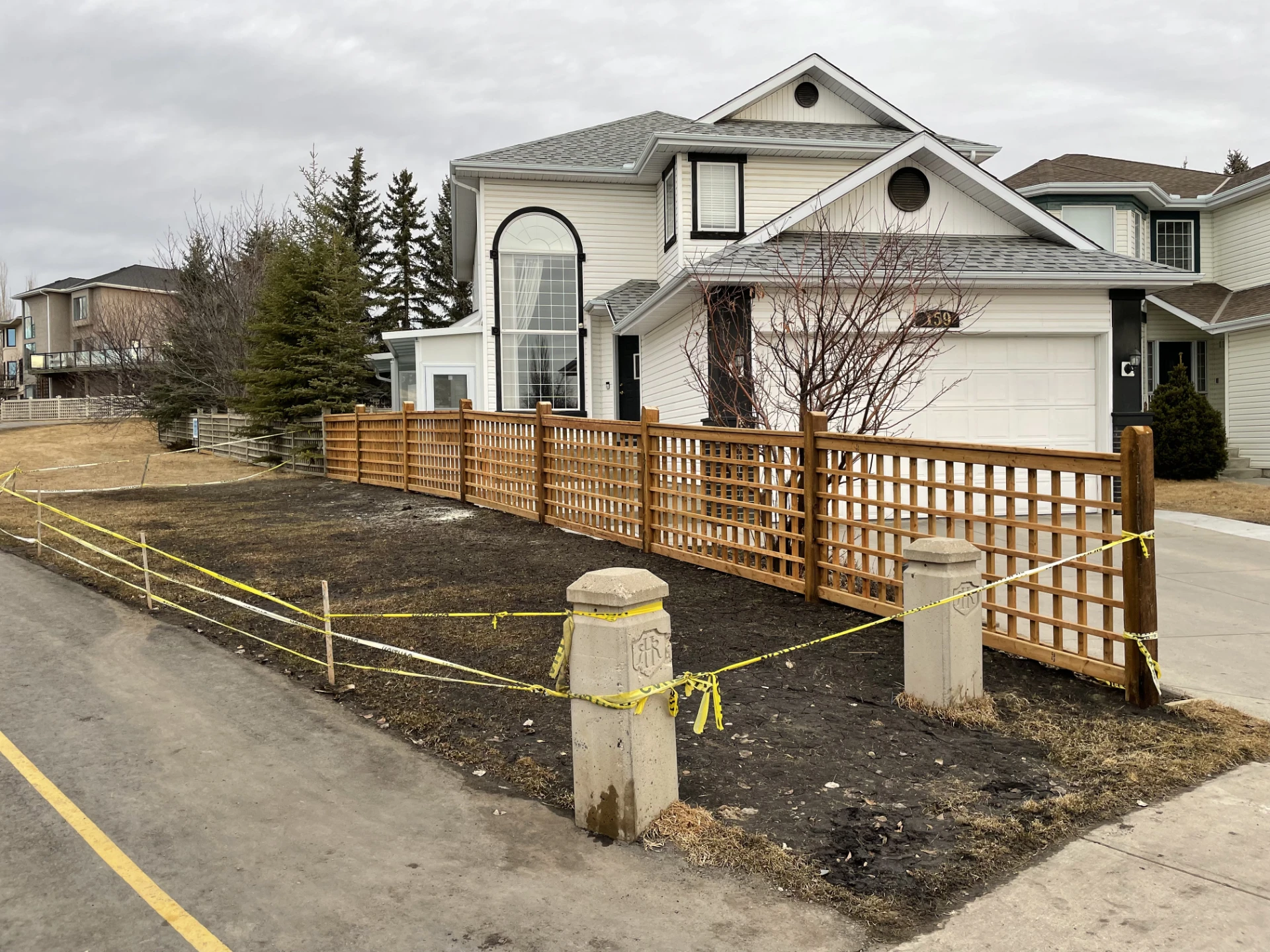 Residential wood lattice fence on the big white house along driveway