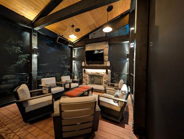 Screened patio room with stone fireplace and vaulted wood ceiling in Calgary, AB
