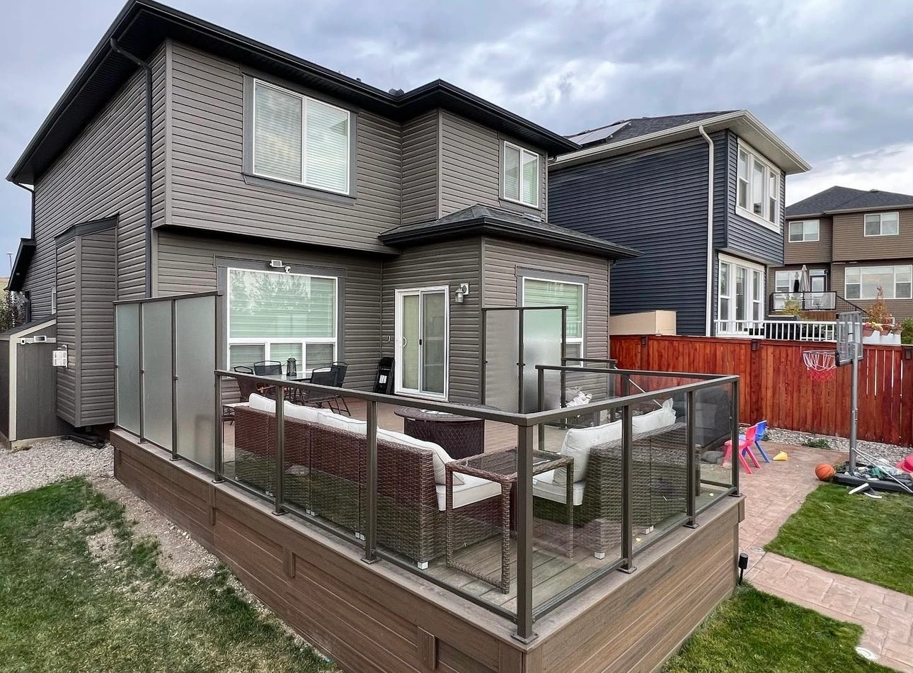 Side view of a residential deck with composite deck boards and glass and metal railing